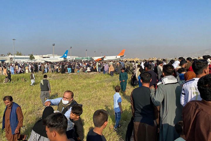 Warga Afghanistan berkerumun di bandara saat mereka menunggu untuk berangkat dari Kabul pada 16 Agustus 2021.