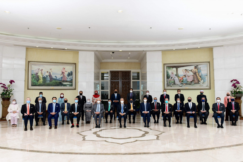 Foto selebaran dari Departemen Penerangan Malaysia yang diambil dan dirilis pada 16 Agustus 2021 ini menunjukkan Perdana Menteri Malaysia Muhyiddin Yassin (tengah) berpose bersama anggota kabinetnya setelah pertemuan di Kantor Perdana Menteri Malaysia di Putrajaya. 