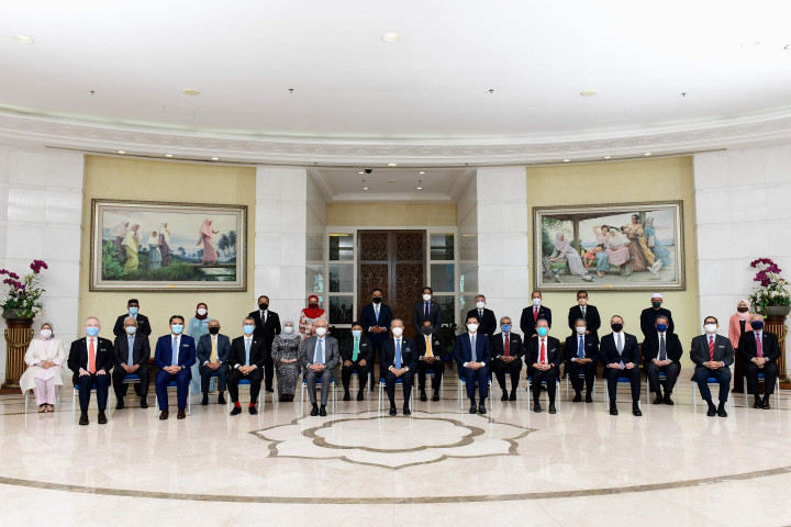 Foto selebaran dari Departemen Penerangan Malaysia yang diambil dan dirilis pada 16 Agustus 2021 ini menunjukkan Perdana Menteri Malaysia Muhyiddin Yassin (tengah) berpose bersama anggota kabinetnya setelah pertemuan di Kantor Perdana Menteri Malaysia di Putrajaya. 