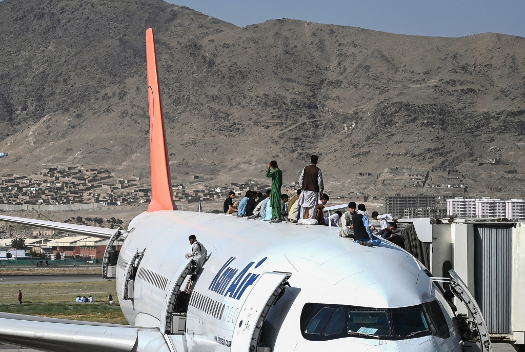 Sejumlah warga Afghanistan nekat menaiki atap pesawat saat mereka ramai-ramai menyerbu bandara Kabul.