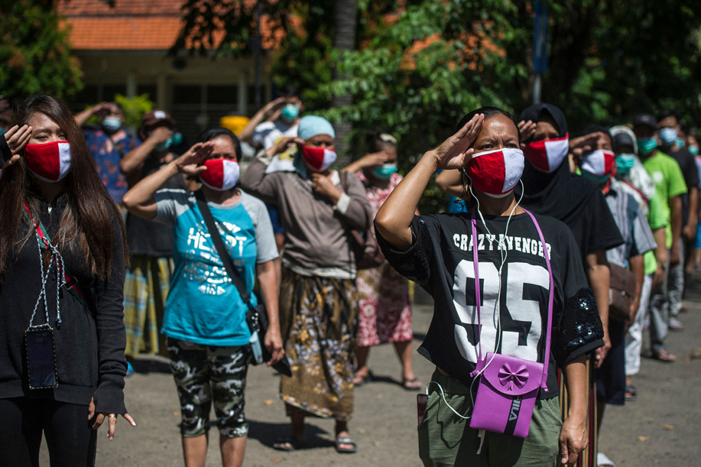 Pasien OTG covid-19 mengikuti upacara Hari Kemerdekaan RI di luar rumah sakit rujukan Covid-19 di Surabaya. AFP Photo/Juni Kriswanto