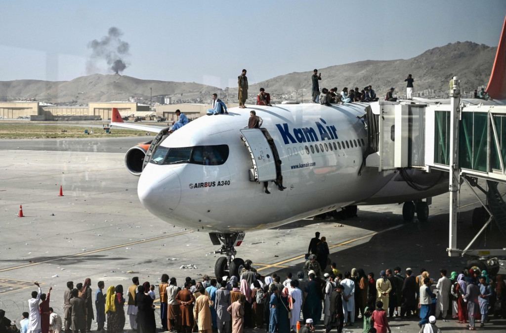 Sejumlah warga Afghanistan nekat menaiki atap pesawat saat mereka ramai-ramai menyerbu bandara Kabul.