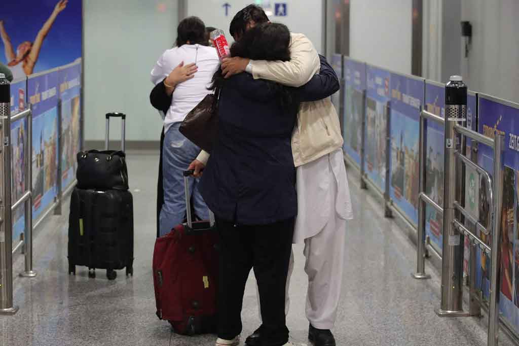 Orang-orang berpelukan setelah turun dari pesawat Lufthansa yang mengangkut pengungsi dari Afghanistan, di Bandara Internasional Frankfurt, Rabu, 18 Agustus 2021 dini hari waktu setempat.