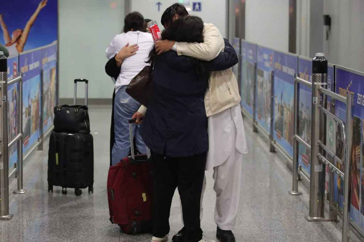 Orang-orang berpelukan setelah turun dari pesawat Lufthansa yang mengangkut pengungsi dari Afghanistan, di Bandara Internasional Frankfurt, Rabu, 18 Agustus 2021 dini hari waktu setempat.