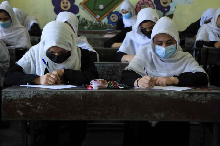Gadis-gadis yang mengenakan jilbab putih dan tunik hitam berdesakan di ruang kelas di kota Herat, Afghanistan barat, hanya beberapa hari setelah negara tersebut diambil alih oleh Taliban.