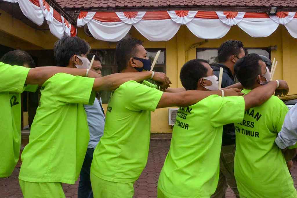 Personel Kepolisian Polres Aceh Timur membawa pelaku tindak kejahatan pemburuan hewan dilindungi berupa gajah, saat konferensi pers di Mapolres Aceh Timur, Aceh, Kamis, 19 Agustus 2021.