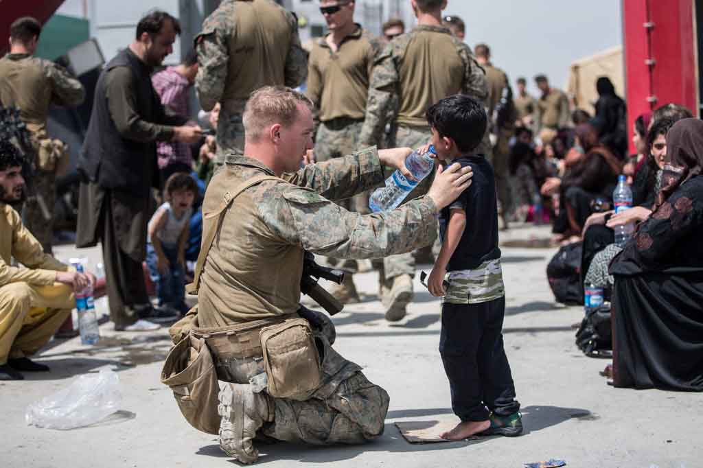 Di gambar lain lagi menggambarkan salah satu tentara AS memberikan air kepada seorang anak kecil. 