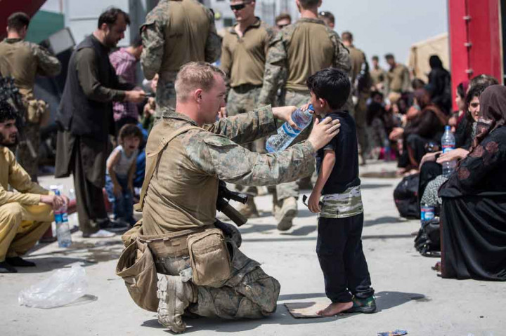 Di gambar lain lagi menggambarkan salah satu tentara AS memberikan air kepada seorang anak kecil. 