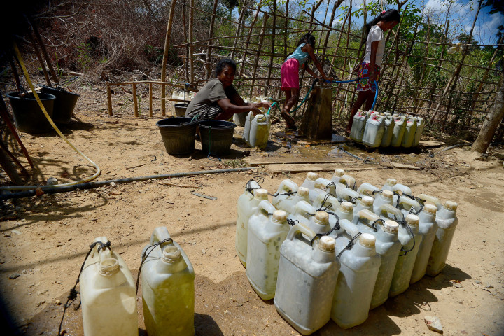 Warga antre mengisi air bersih ke dalam jeriken di Desa Uiasa, Semau, Nusa Tenggara Timur, Minggu, 23 Agustus 2021. 