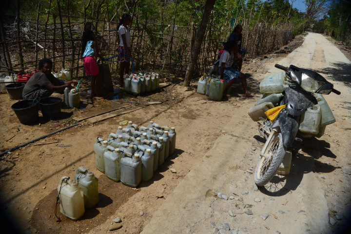 Warga antre mengisi air bersih ke dalam jeriken di Desa Uiasa, Semau, Nusa Tenggara Timur, Minggu, 23 Agustus 2021. 
