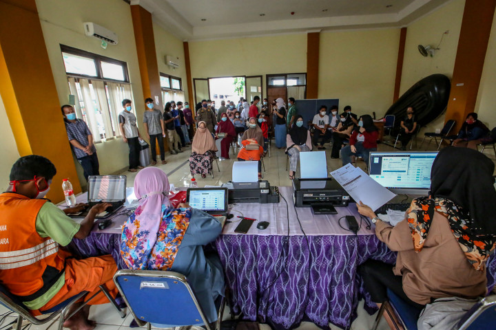 Warga mengantre untuk mengambil sertifikat vaksinasi covid-19 saat mobil vaksin keliling singgah di Gedung Balai Kesehatan RS Pondok, Cipinang Muara, Jakarta.