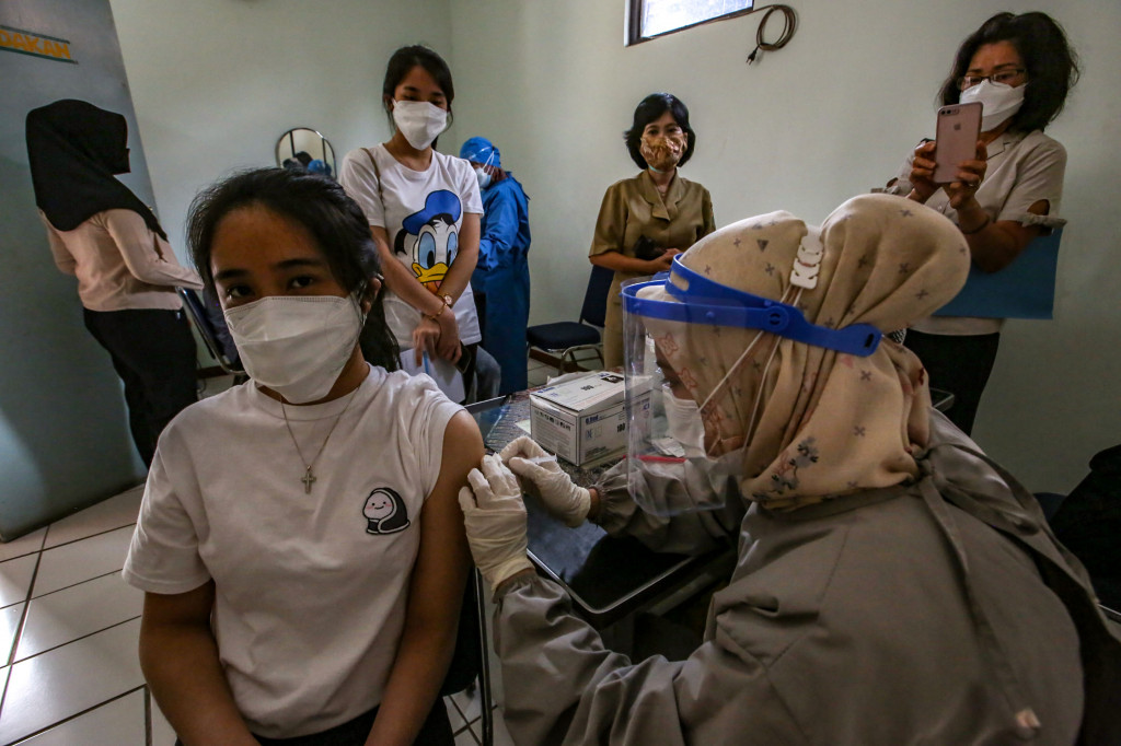 Petugas kesehatan menyuntikkan vaksin kepada warga saat mobil vaksin keliling singgah di Gedung Balai Kesehatan RS Pondok, Cipinang Muara, Jakarta.