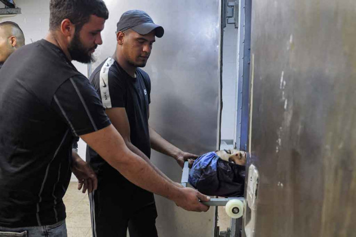 Seorang pria mengeluarkan jenazah seorang remaja Palestina yang ditembak mati tentara Israel dari sebuah lemari es di kamar jenazh Rumah Sakit Rafedya di Kota Nablus, Tepi Barat pada Selasa, 24 Agustus 2021.