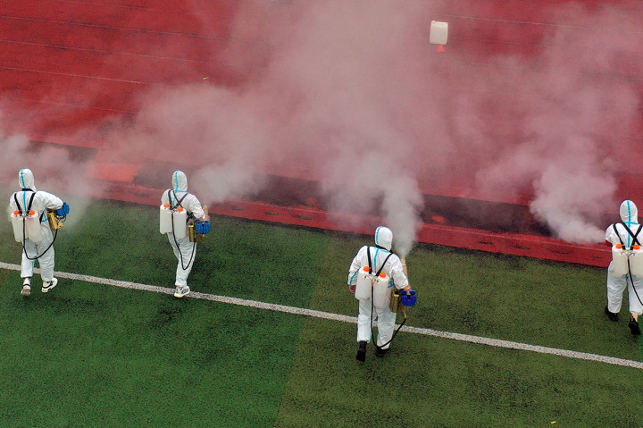 Pandangan udara sejumlah petugas memakai APD saat menyemprotkan disinfektan di sebuah sekolah menjelang semester baru di Bozhou, Tiongkok, Senin, 23 Agustus 2021.