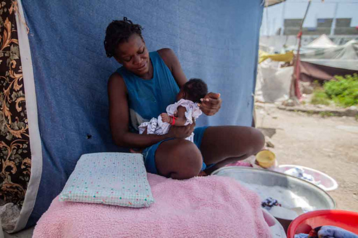 Rumah bagi Guerrier, suami dan tiga anaknya adalah tempat perlindungan tipis yang terbuat dari tongkat dan lembaran plastik di sebuah pusat olahraga di kota Les Cayes yang dilanda bencana, di semenanjung barat daya ibu kota Port-au-Prince. 