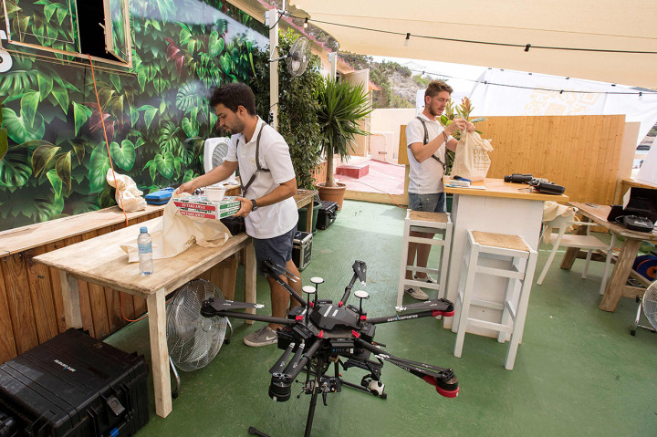 Pilot drone menyiapkan kantong makanan untuk dilampirkan ke drone dari Cala Tadira dekat Sant Josep de Sa Talaia di Pulau Ibiza, Spanyol.