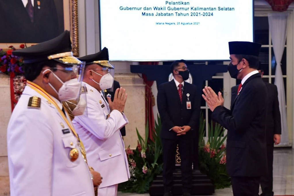 Presiden Joko Widodo (kanan) memberi selamat kepada Sahbirin Noor dan dan Muhidin usai dilantik sebagai Gubernur dan Wakil Gubernur Kalimantan Selatan di Istana Kepresidenan, Jakarta, Rabu, 25 Agustus 2021.