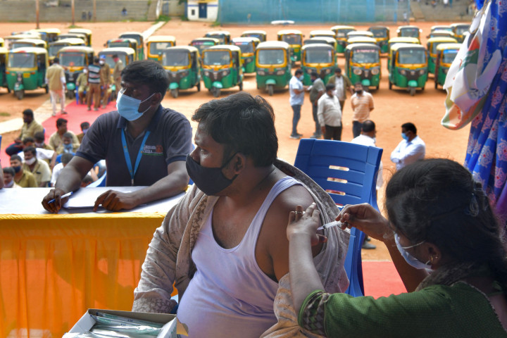 Seorang pengemudi bajaj saat disuntik vaksin Covid-19 CoviShield selama vaksinasi gratis di Bangalore, India.