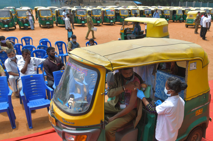 Seorang pengemudi bajaj saat disuntik vaksin Covid-19 CoviShield selama vaksinasi gratis di Bangalore, India.