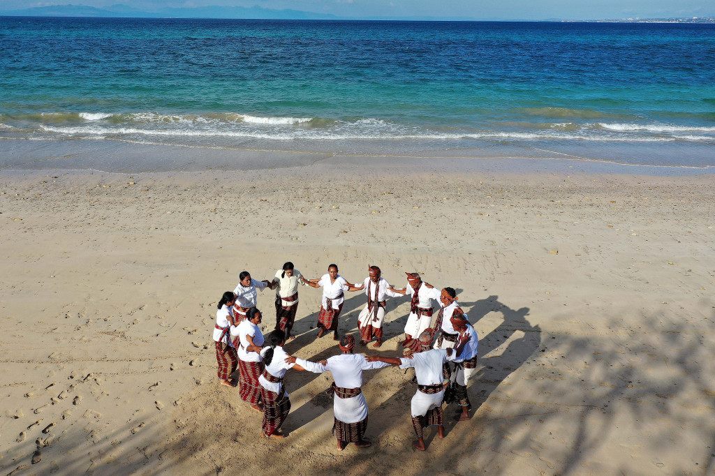 Warga desa pria dan wanita membawakan tarian Li Ngae di Pantai Uiasa, Pulau Semau, Nusa Tenggara Timur, Rabu, 25 Agustus 2021.