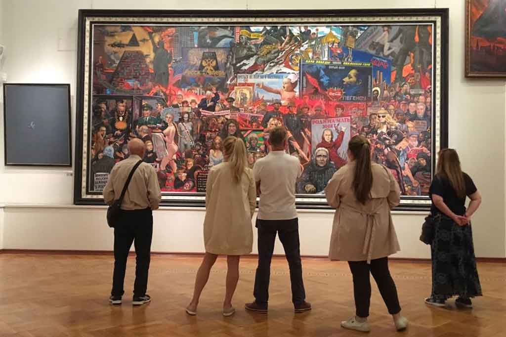 Pengunjung memperhatikan lukisan berjudul The Market of Our Democracy (1999), cat minyak di atas canvas 297x 599, karya Ilya Glazunov yang dipamerkan di Galeri Glazunov, Moskwa. 