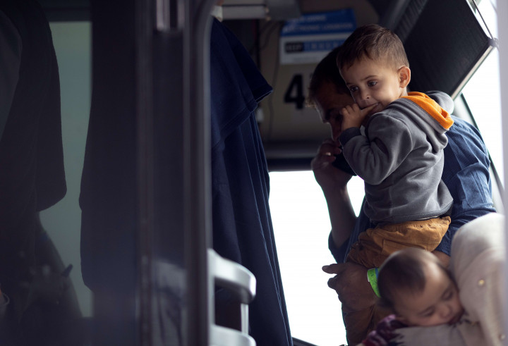 Pengungsi yang dievakuasi dari Kabul Afghanistan menaiki bus di Bandara Internasional Dulles yang akan membawa mereka ke pusat pemrosesan pengungsi pada 26 Agustus 2021 di Dulles, Virginia.
