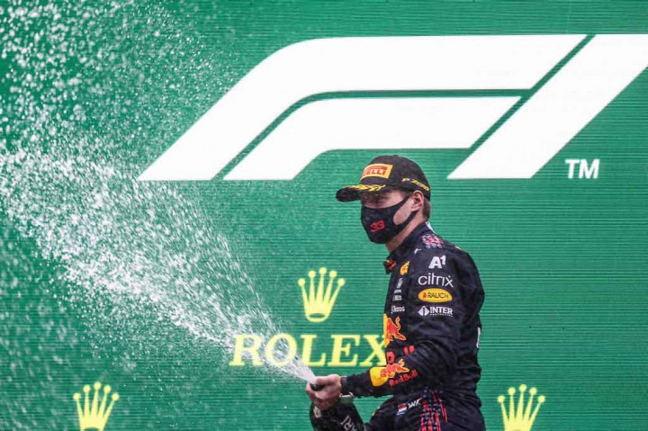Pembalap Red Bull asal Belanda Max Verstappen menyemprotkan sampanye saat merayakan kemenangannya di Grand Prix Formula Satu Belgia, di sirkuit Spa-Francorchamps, di Spa pada Minggu, 29 Agustus 2021.