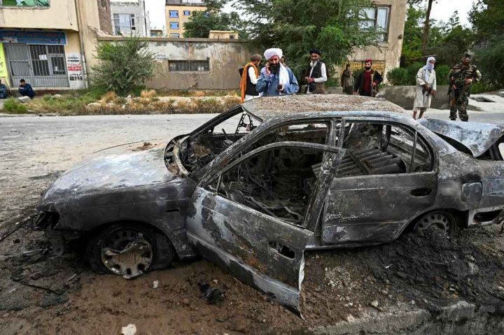 Pejuang Taliban menyelidiki mobil yang rusak setelah beberapa roket ditembakkan di sekitar bandara Kabul, Afghanistan pada Senin, 30 Agustus 2021.