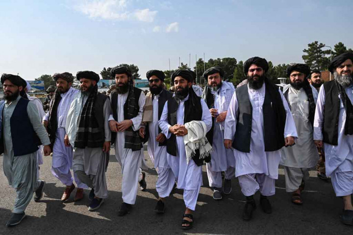 Beberapa jam setelah pasukan asing terakhir terbang keluar dari Afghanistan, para pemimpin Taliban berjalan dengan penuh kemenangan melalui bandara, diapit oleh pasukan khusus yang mengenakan peralatan tempur.
