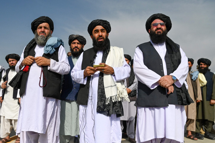 Dilansir AFP, Selasa, 31 Agustus 2021, juru bicara Taliban, Zabihullah Mujahid, memimpin rombongan petinggi Taliban berjalan ke landasan bandara Kabul pada Selasa, 31 Agustus 2021, waktu setempat.