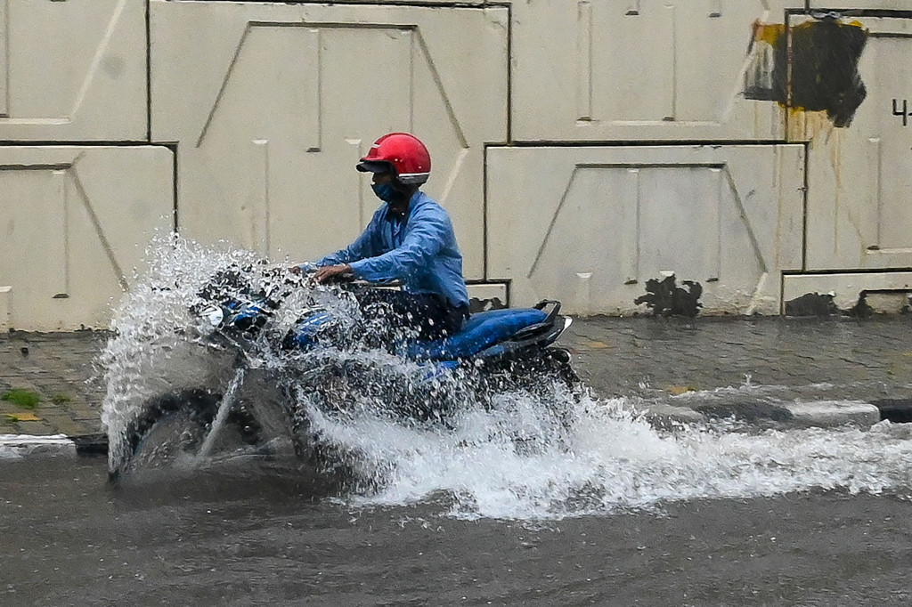 Pengendara sepeda motor menerobos genangan banjir setelah hujan lebat mengguyur seharian di New Delhi, India, Rabu, 1 September 2021.