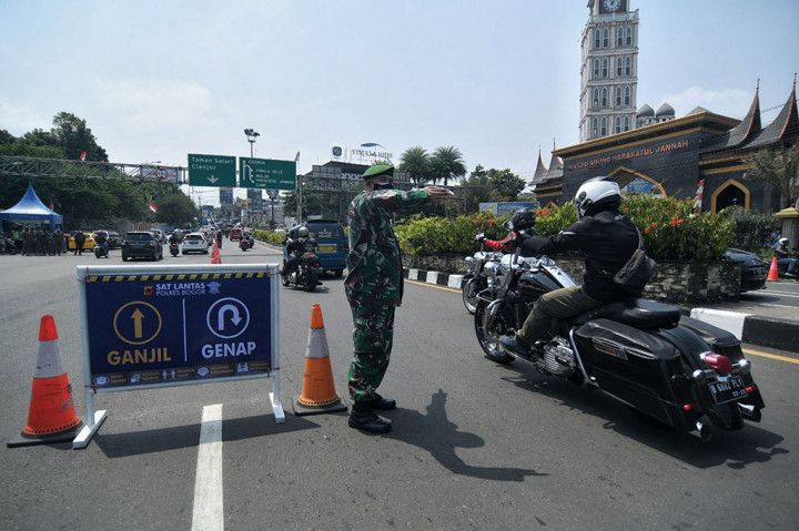 Petugas gabungan saat membantu mendorong kendaraan roda 4 dengan plat nomer genap yang mogok saat diminta putar balik di Simpang Gadog, Bogor, Jawa Barat, Jumat, 3 September 2021.
