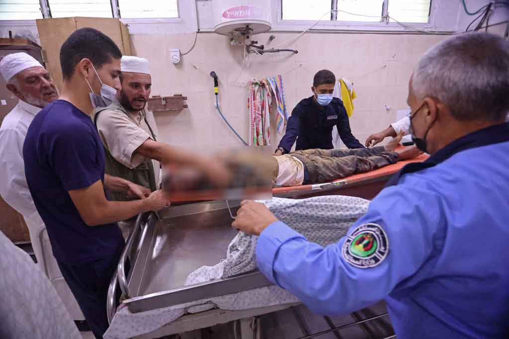 Para pekerja mengangkat jenazah Issa Abu al-Hassum, yang tertimbun di terowongan penyelundupan dekat perbatasan Rafah ke Mesir, di kamar mayat sebuah rumah sakit di selatan Jalur Gaza pada Jumat, 3 September 2021.