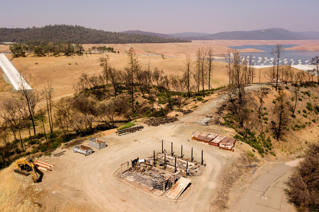 Properti yang terbakar terlihat di atas Danau Oroville yang surut di Oroville, California, Amerika Serikat, Minggu, 5 September 2021.