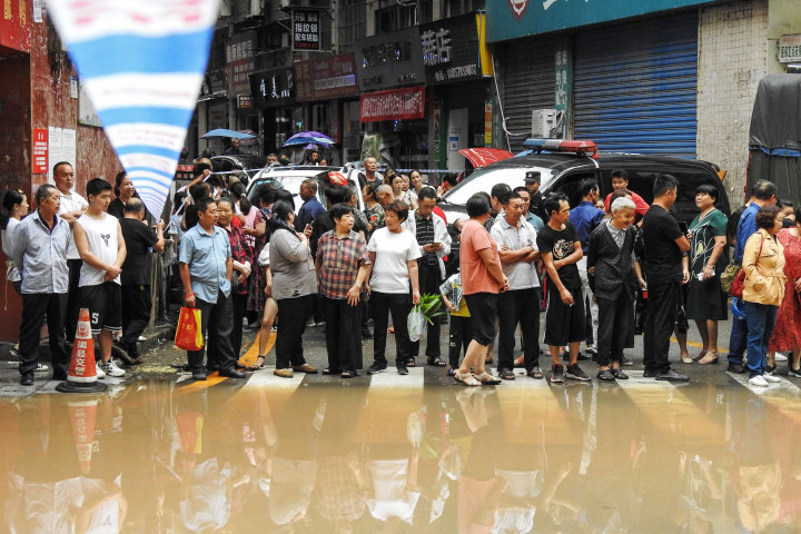 Warga melihat daerah banjir setelah hujan deras di daerah Quxian, kota Dazhou, di provinsi Sichuan, barat laut Tiongkok.