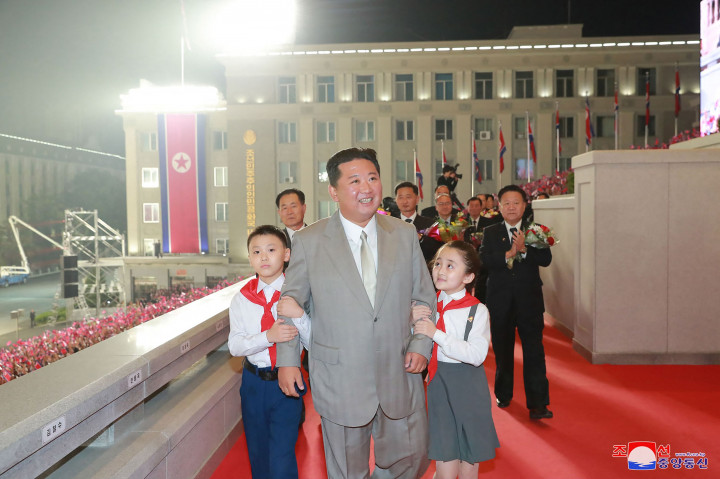 Dalam parade yang digelar pada Rabu, 8 September 2021, itu, Kim terlihat mengenakan jas abu-abu dengan dasi putih mengkilap. Meski parade digelar pada tengah malam, Kim tampak sangat ceria ketika menyapa anak-anak yang menyambutnya di acara tersebut.