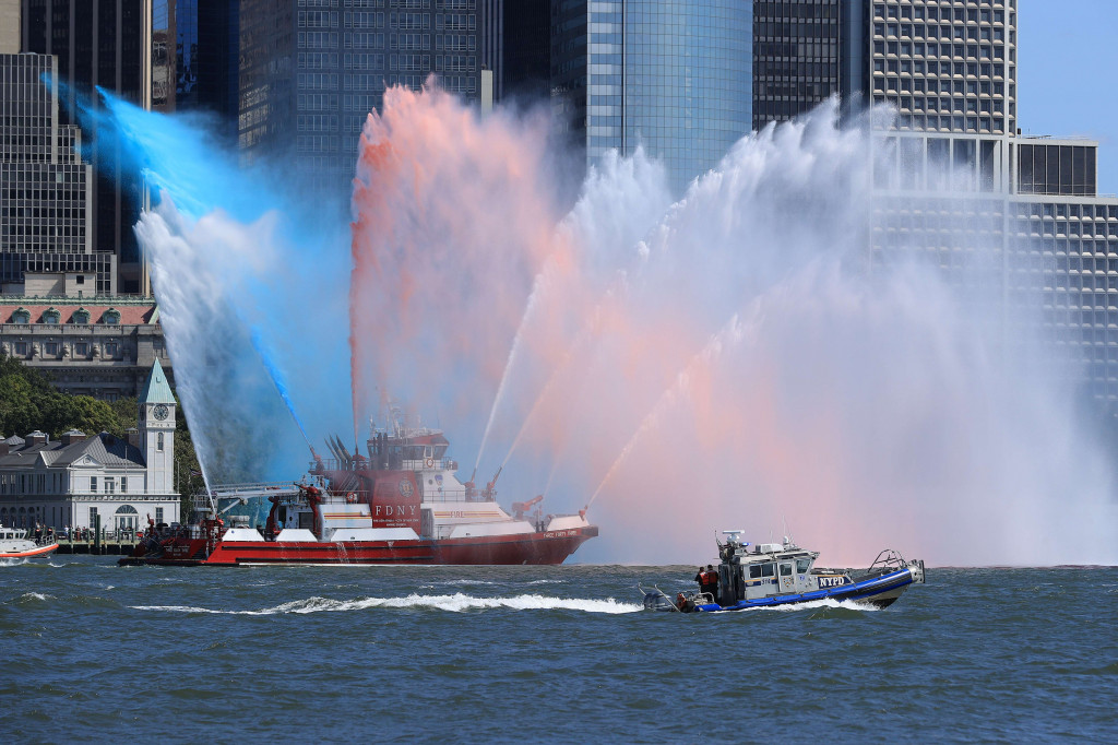 Kapal pemadam kebakaran NYFD Three Forty Three menyemprotkan air ke armada kapal yang lewat selama peringatan 20 tahun pengangkatan kapal 11 September di Sungai Hudson di sepanjang Lower Manhattan pada 10 September 2021 di New York City. 