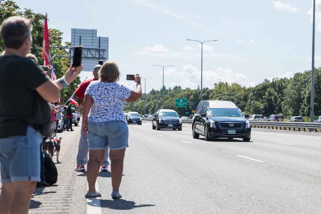 Warga berbaris di sepanjang I-93 North saat iring-iringan yang membawa mendiang Sersan Marinir Johanny Rosario Pichardo melewati I-93 North di Stoneham, Massachusetts, pada 11 September 2021 waktu setempat.