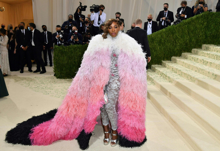 Serena Williams menghadiri The 2021 Met Gala Celebrating In America: A Lexicon Of Fashion di Metropolitan Museum of Art di New York City. Merek mode fashion Gucci dipakai oleh Serena Williams. Ia menampilkan jubah multi-warna berjenjang yang menghiasi setelan perak renda rumit di bawahnya.