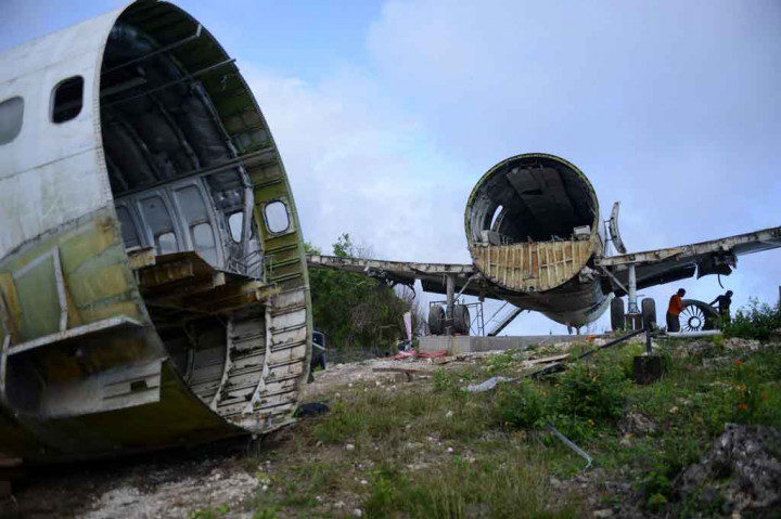 Lebih dari selusin pekerja menggunakan derek untuk merakit bagian-bagian dari Boeing 737 di tebing dekat Pantai Nyang-Nyang minggu ini.