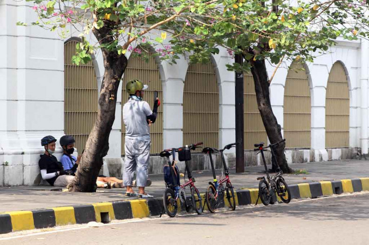 Warga beristirahat setelah melakukan aktivitas di kawasan Kota Tua, Jakarta, Minggu, 19 September 2021. 