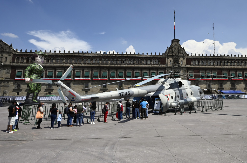 Orang-orang mengantre untuk masuk ke helikopter MI-17 Angkatan Udara Meksiko dalam pameran yang disebut The Great Force of Mexico di Alun-alun Zocalo, Mexico City, Meksiko, 20 September 2021.