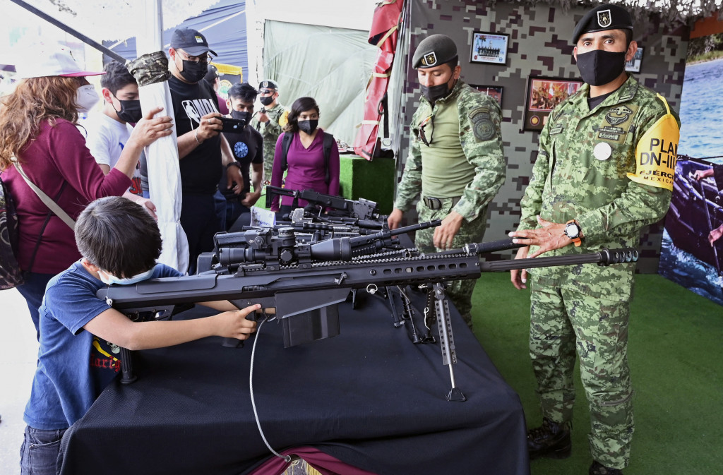 Seorang anak laki-laki mencoba senjata yang digunakan oleh Tentara Meksiko dalam pameran yang disebut The Great Force of Mexico di Alun-alun Zocalo, Mexico City, Meksiko, 20 September 2021.