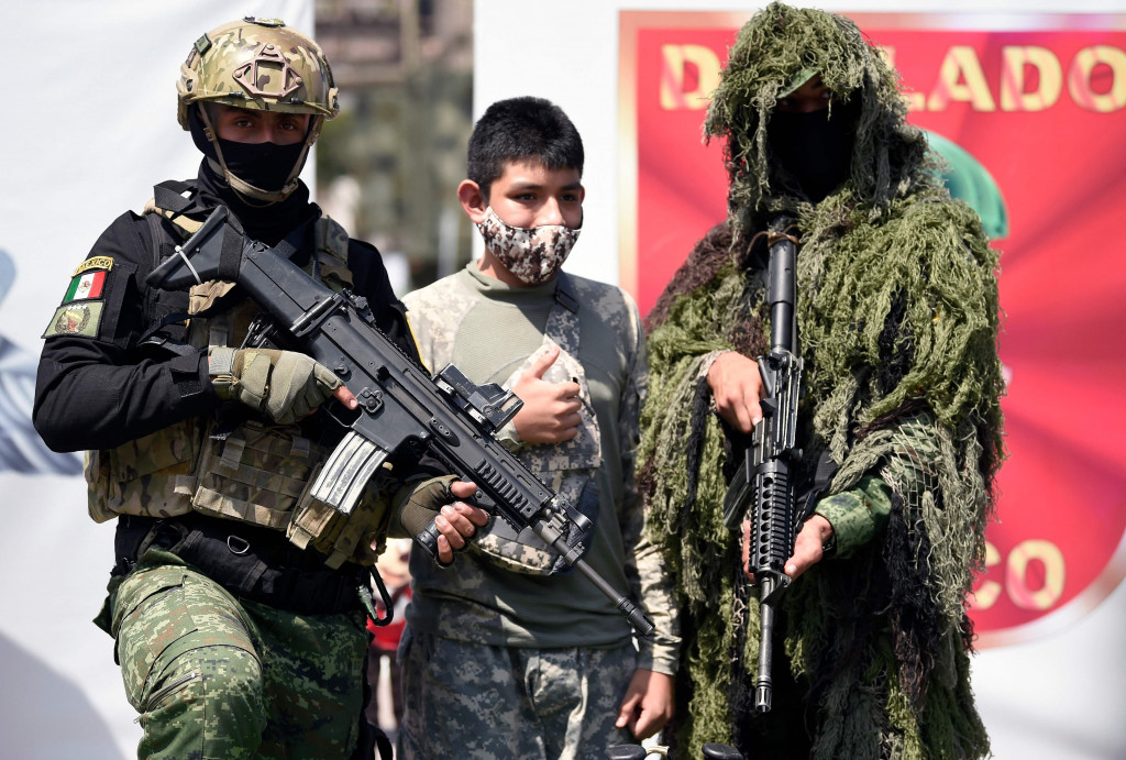 Seorang remaja berfoto dengan anggota Pasukan Khusus Angkatan Darat Meksiko, selama pameran yang disebut The Great Force of Mexico di Alun-alun Zocalo, Mexico City, Meksiko, 20 September 2021.
