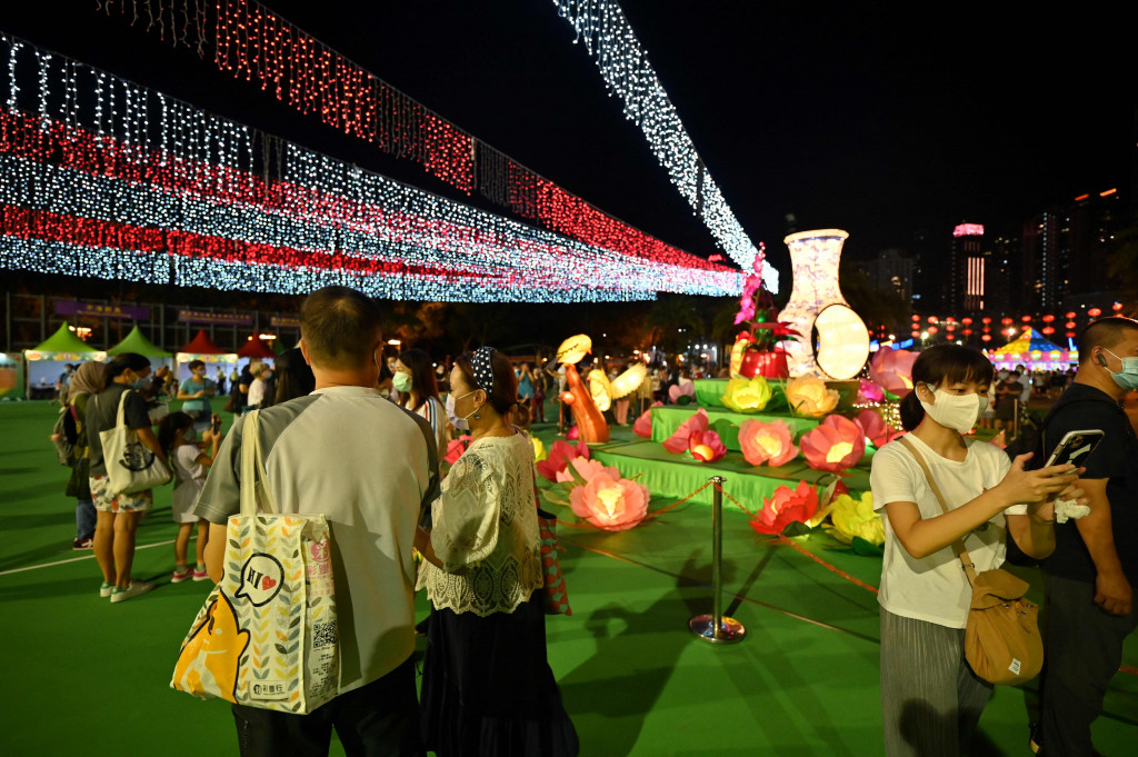 Orang-orang mengambil gambar dekorasi selama Festival Pertengahan Musim Gugur digelar di taman Victoria, di Hong Kong, Selasa, 21 September 2021.
