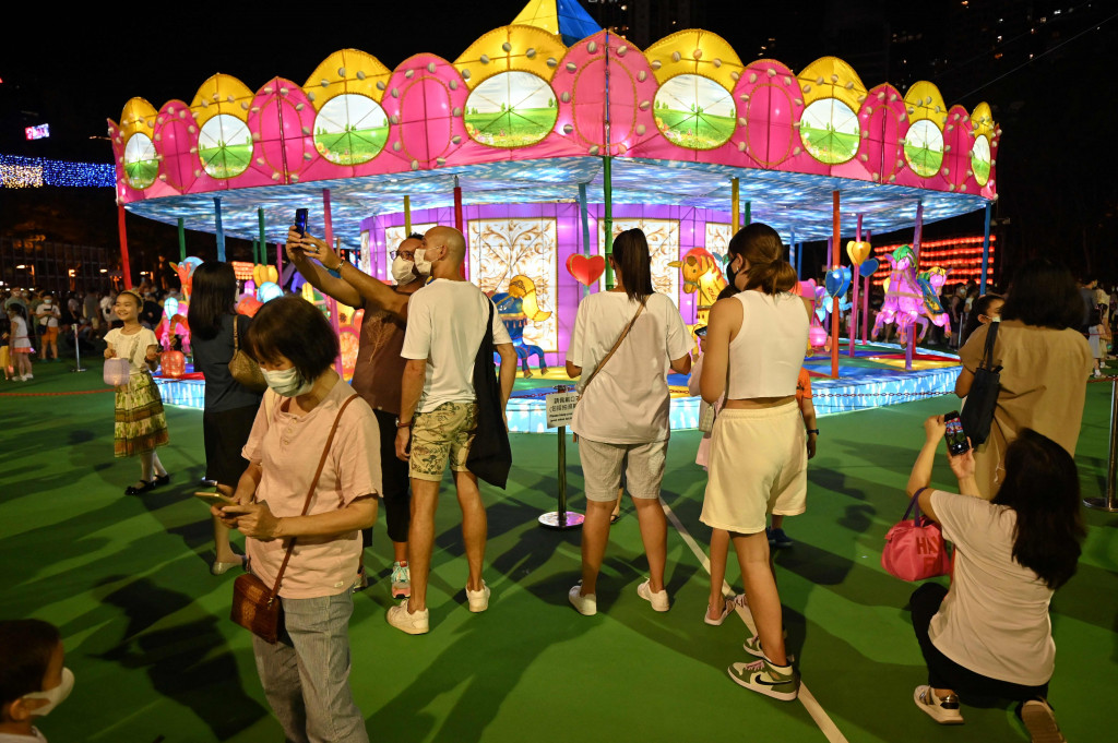 Pengunjung berfoto di depan dekorari selama Festival Pertengahan Musim Gugur digelar di taman Victoria, di Hong Kong, Selasa, 21 September 2021.