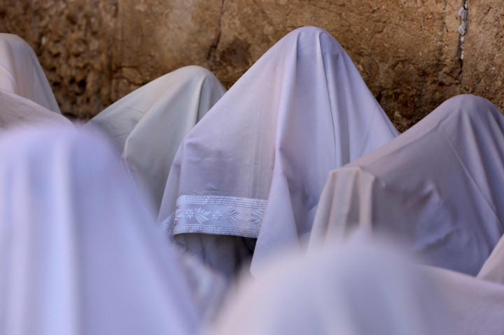 Pria Yahudi ultra-ortodoks dari kasta Cohanim Priestly berdoa dengan menggunakan selendang saat mereka berpartisipasi dalm pemberkatan selama hari raya Yahudi Sukkot di Tembok Barat, situs paling suci di Kota Tua Yerusalem, Rabu, 22 September 2021.