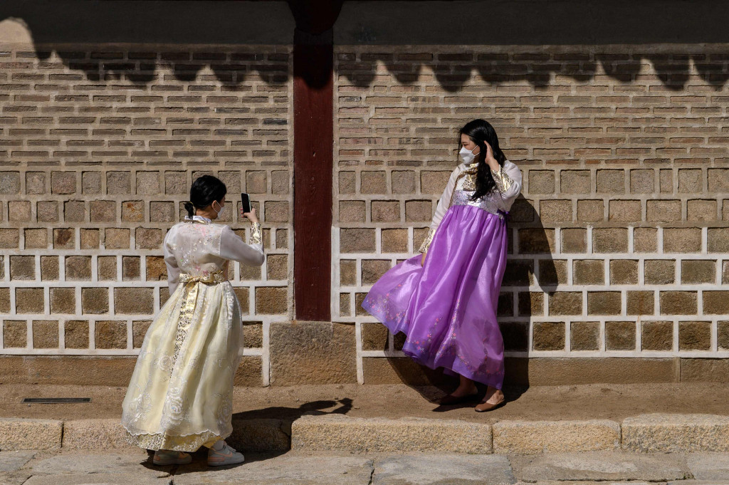 Pengunjung berfoto menggunakan pakaian tradisional hanbok di Istana Gyeongbok di Seoul, Korea Selatan, 20 September 2021, sehari sebelum liburan Chuseok.
