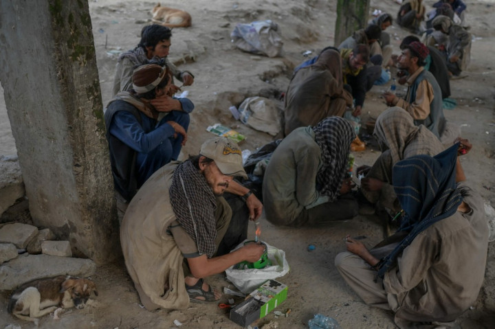 Pecandu narkoba duduk di pinggir jalan saat mereka mengonsumsi narkoba di Kabul, Afghanistan, Selasa, 21 September 2021. Para pecandu ini tampak dengan bebas mengonsumsi narkoba di depan umum.