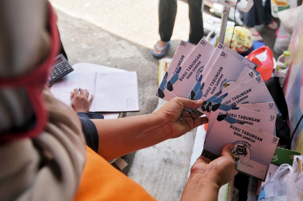 Warga menunjukkan buku tabungan sampah di Bank Sampah 68, RT 06/RW 08, Kelurahan Kebagusan, Pasar Minggu, Jakarta, Kamis, 23 September 2021.